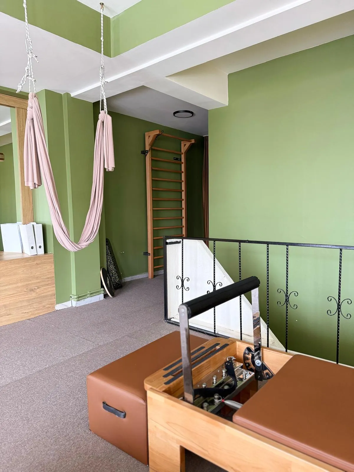 Elafiz Fizyoterapi'de egzersiz matları, pilates çemberi, dumbbell seti ve direnç bantlarının yer aldığı ekipman duvarı