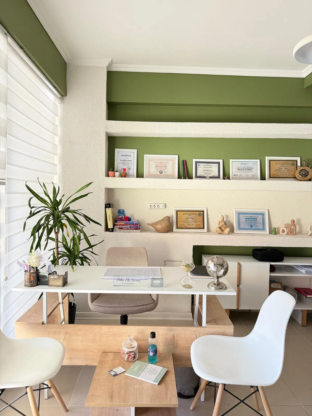 Elafiz Fizyoterapi'de sertifikaların bulunduğu çalışma masası ve danışan oturma alanı